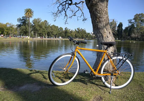 Vélo posé devant le lac d'un parc arboré de Buenos Aires 